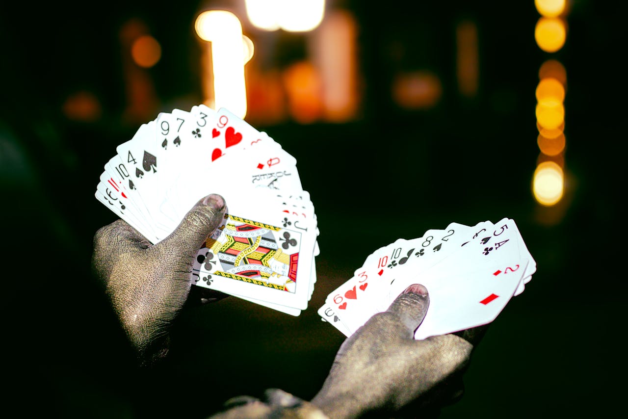 Services A magician showcases a deck of playing cards with dramatic lighting at night, highlighting a sense of mystery and intrigue.